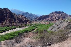 06 Our First Stop View Of River Flowing Through A Fertile Valley With Eroded Red Hills In Quebrada de Cafayate South Of Salta.jpg